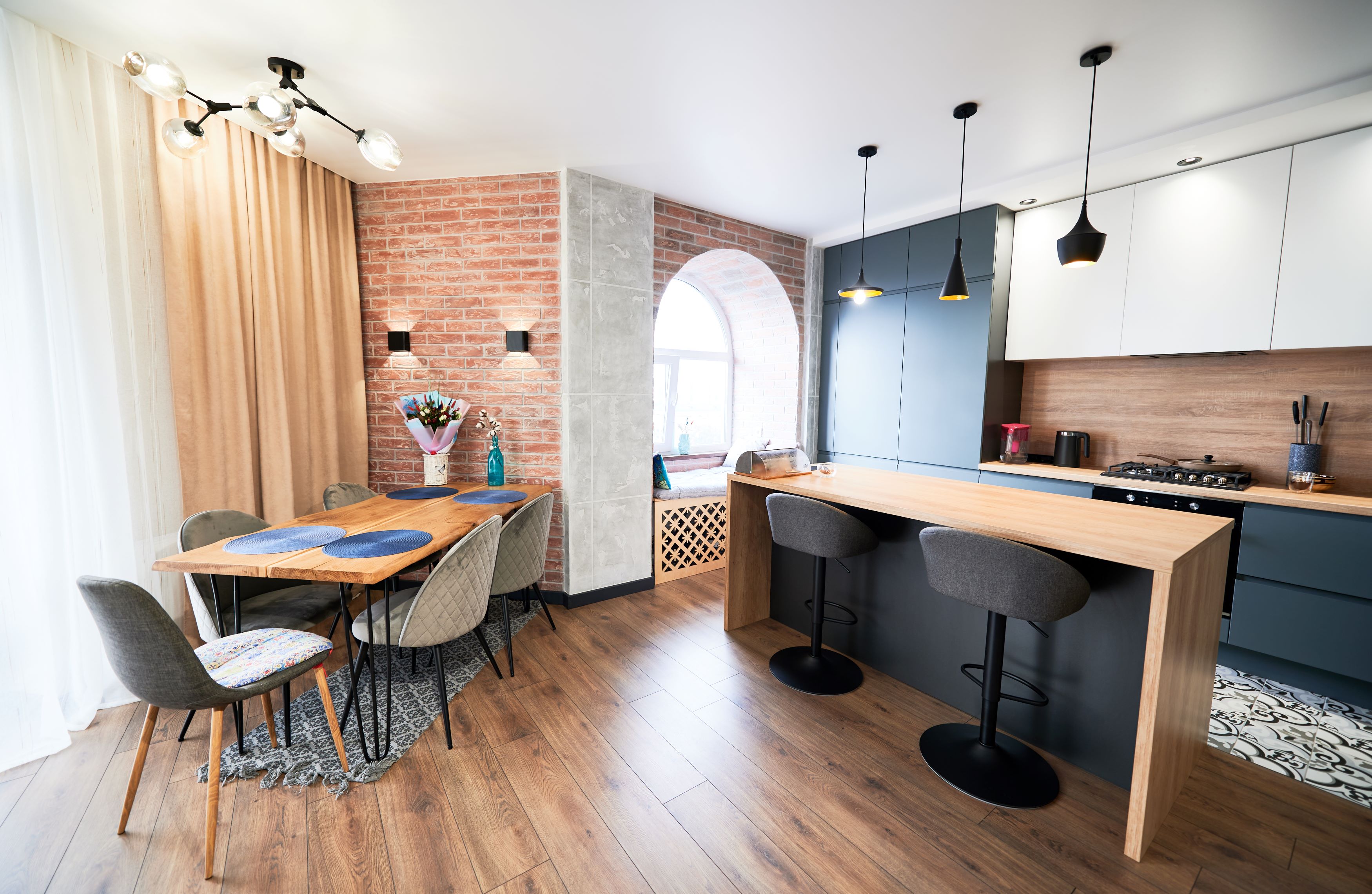 Whole-home renovation — open-plan living and dining with warm wood and cream plaster